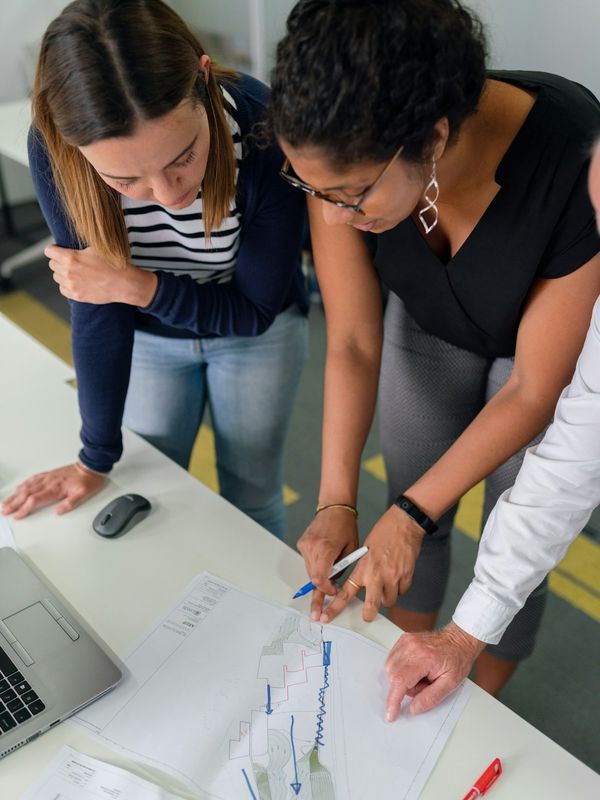 Two colleagues reviewing a printed document together at a desk