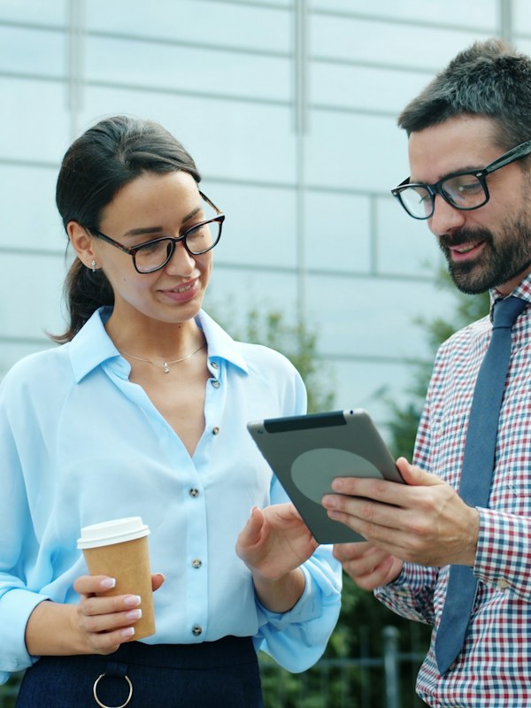 Two colleagues reviewing information together on a tablet
