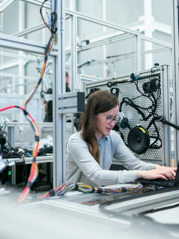 An engineer working on a laptop on a production floor