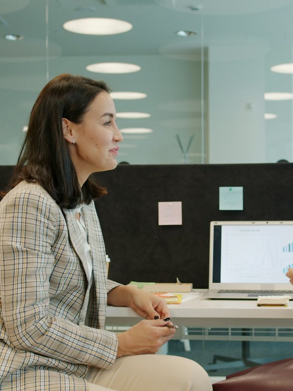 Colleagues talking at a desk in an office