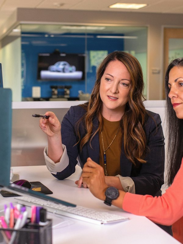 Two colleagues working through something together at a desk